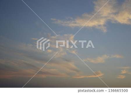 Sunbeams or light beams breaking through the clouds on a blue sky during sunset 136665500