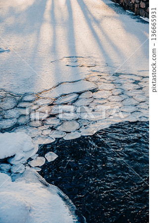 Winter river with floating ice floes and snow, abstract cold water texture Winter river with floating ice floes and snow, abstract cold water texture 136665931