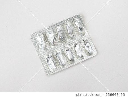 Empty foil blister pack for capsules isolated on white background. Used medications. Healthcare and medicine 136667433
