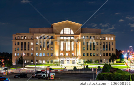 Nathan Deal Judicial Center in Atlanta, Georgia. Modern government building features a stone facade with columns and large glass windows illuminated at night 136668191