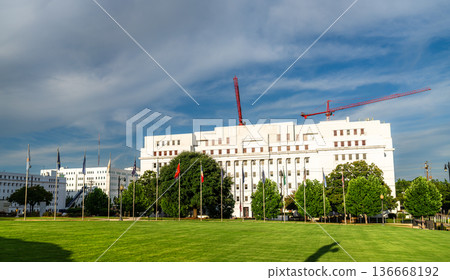 Alabama State House in Montgomery. White limestone government building features the Avenue of Flags on the State Capitol lawn under a blue sky Alabama State House in Montgomery. White limestone government building features the Avenue of Flags on the State Capitol lawn under a blue sky 136668192