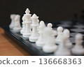 Close up of white chess pieces on board with focus on King. Strategic competition, leadership business success, management planning, marketing vision and corporate thinking challenge concept. 136668363