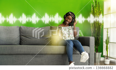 Podcast recording session with a smiling woman sitting on a couch in a green room Podcast recording session with a smiling woman sitting on a couch in a green room 136668882