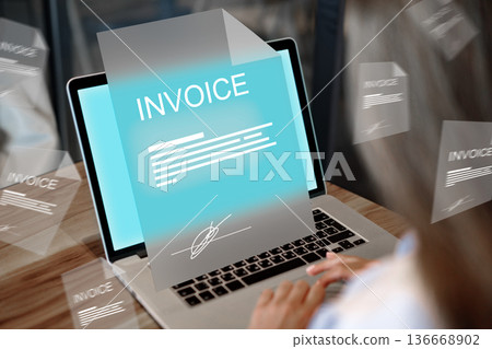 Invoice payment being processed on a laptop in a work setting during daytime hours 136668902