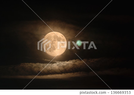 Full Moon Behind Thin Clouds in Dark Night Sky 136669353