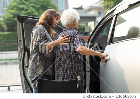 Caregiver help Asian elderly woman disability patient get in her car. Caregiver help Asian elderly woman disability patient get in her car. 136669572