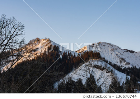 Snow-capped mountains and melting snow at dusk 136670744