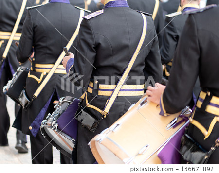 Rear view of a musical band member playing drums during a religious procession 136671092