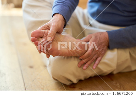 Senior Asian man holding his sore soles Senior Asian man holding his sore soles 136671200