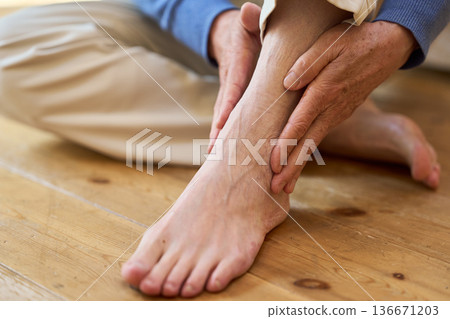 一位年長的亞裔男子摀著疼痛的腳踝 136671203