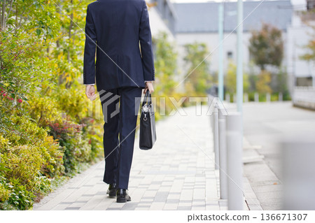 一位二十多歲的商人正在戶外散步。 一位二十多歲的商人正在戶外散步。 136671307