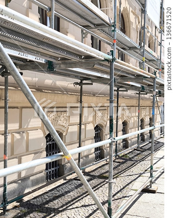 Urban renewal: the facade of an old building covered in scaffolding Urban renewal: the facade of an old building covered in scaffolding 136671520