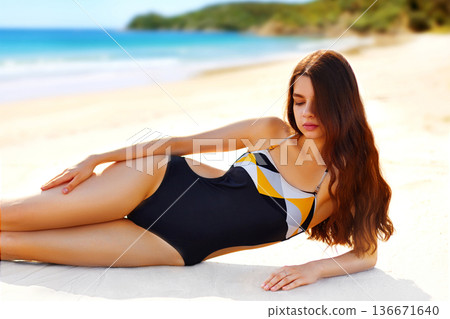 Portrait of glamorous young woman enjoying the peaceful nature on beach Portrait of glamorous young woman enjoying the peaceful nature on beach 136671640