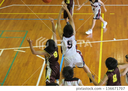 Players playing basketball in the gym 136671707