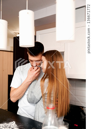 Couple sharing a moment in modern kitchen as they embrace and show affection during a casual day at home Couple sharing a moment in modern kitchen as they embrace and show affection during a casual day at home 136671772