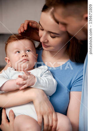 Family shares a moment together with their baby during a quiet afternoon in their home living room Family shares a moment together with their baby during a quiet afternoon in their home living room 136671809