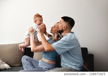 Happy family spends time together playing with baby at home in living room during daylight hours 136671825
