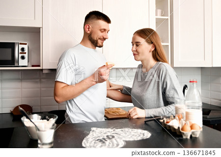 Couple prepares food together in a kitchen while sharing a moment and enjoying homemade treats on a weekend morning Couple prepares food together in a kitchen while sharing a moment and enjoying homemade treats on a weekend morning 136671845