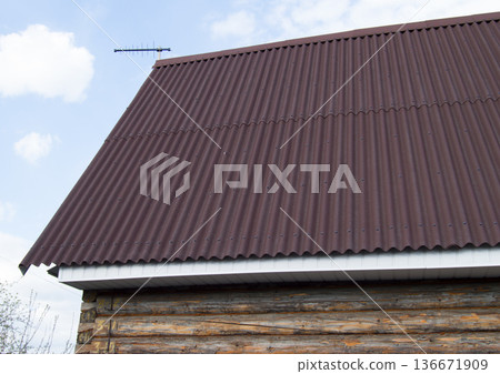 modern construction of the roof with red metal siding to a wooden house in the garden modern construction of the roof with red metal siding to a wooden house in the garden 136671909