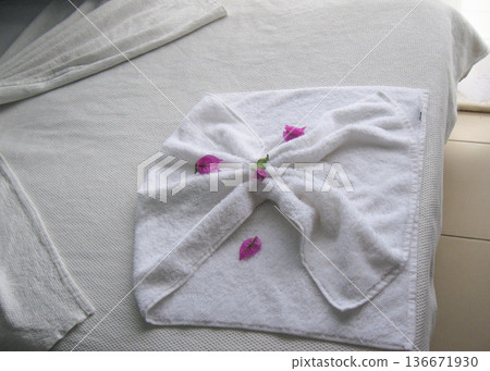 Folded white towel with petals on hotel bed spa mood horizontal 136671930