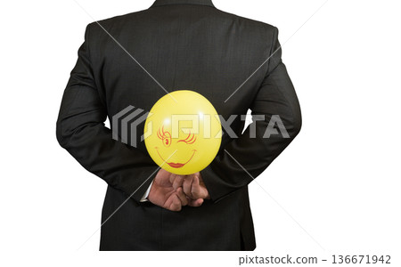 Fool's day is businessman with a balloon behind his back, isolated Fool's day is businessman with a balloon behind his back, isolated 136671942