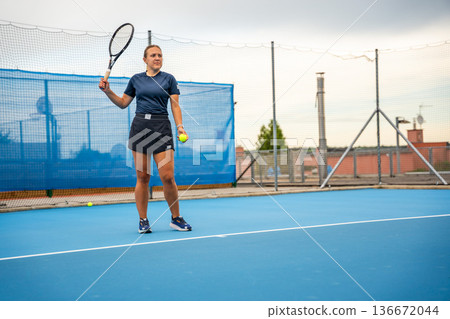 Professional female tennis player playing the tennis on outside court 136672044