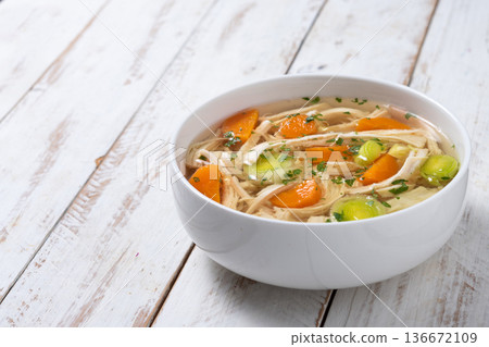 Homemade chicken soup in white bowl with carrots and celery Homemade chicken soup in white bowl with carrots and celery 136672109