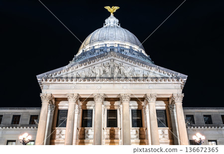 Mississippi State Capitol building in Jackson. Historic Beaux-Arts government architecture features illuminated Corinthian columns and a dome topped with a gold eagle statue at night Mississippi State Capitol building in Jackson. Historic Beaux-Arts government architecture features illuminated Corinthian columns and a dome topped with a gold eagle statue at night 136672365