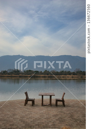 風景優美的湖邊擺放著木桌椅。 風景優美的湖邊擺放著木桌椅。 136672560