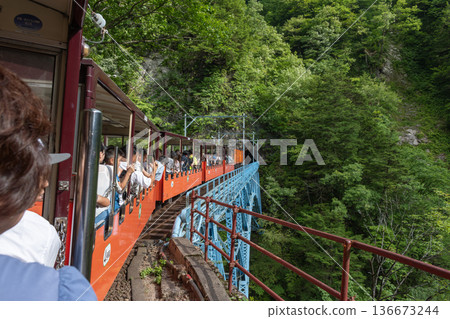 A trolley train running against the backdrop of mountains A trolley train running against the backdrop of mountains 136673244
