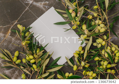 Premium olive oil branding mockup with fresh green olives on marble. Blank white card for logo text 136673642