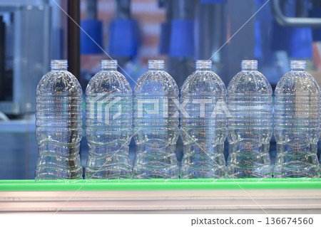 PET Drinking Water Bottles on Conveyor Belt. PET Drinking Water Bottles on Conveyor Belt. 136674560
