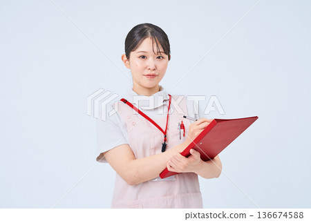 一個穿著白大褂和圍裙的年輕女子 一個穿著白大褂和圍裙的年輕女子 136674588