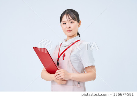 A young woman wearing a white coat and apron A young woman wearing a white coat and apron 136674591