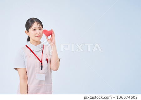 A young woman wearing a white coat and apron A young woman wearing a white coat and apron 136674602