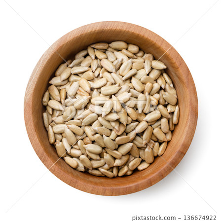 Peeled sunflower seeds, sunflower kernel in a wooden plate on a white background. Top view 136674922