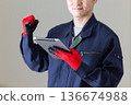 A middle-aged male businessman in work clothes holding a tablet and making a fist pump 136674988