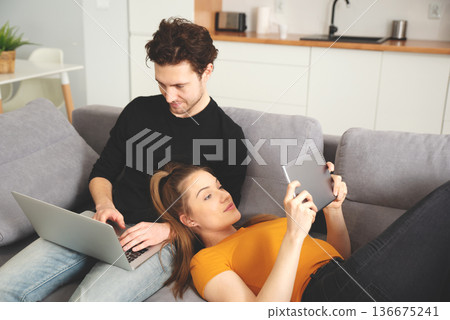 Couple using home internet with mobile devices Couple using home internet with mobile devices 136675241