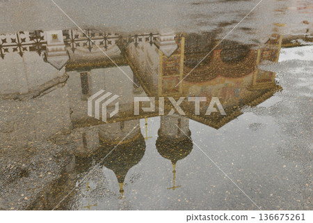 Wet asphalt and an ancient church, reflection, inverted image 136675261