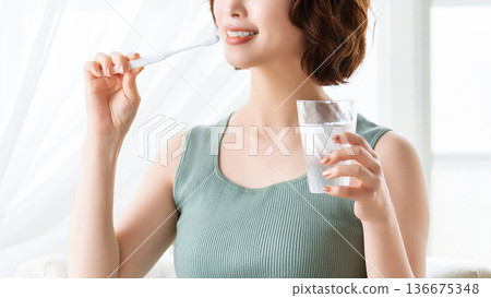 woman brushing teeth woman brushing teeth 136675348