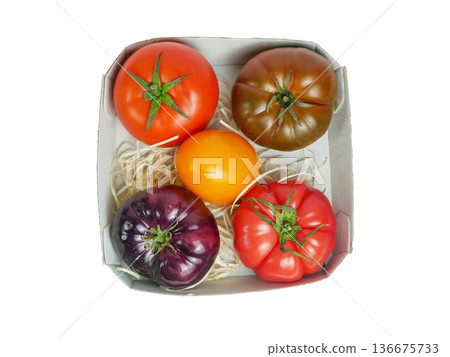 Top view of colorful heirloom tomatoes in a box. Fresh organic farm produce, healthy food, vegan nutrition and gourmet cooking concept isolated on white background Top view of colorful heirloom tomatoes in a box. Fresh organic farm produce, healthy food, vegan nutrition and gourmet cooking concept isolated on white background 136675733