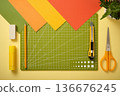 Colorful flat lay of crafting and stationery tools with cutting mat, scissors, knife, pencil, glue and paper sheets. Copy space 136676245