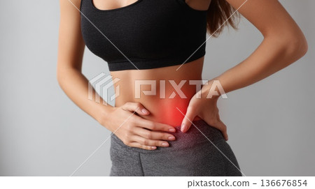 Woman with abdominal pain holding stomach in discomfort 136676854