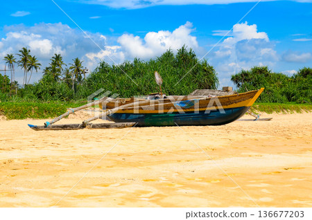 Colorful Sri Lankan fishing catamaran parked on golden sand Colorful Sri Lankan fishing catamaran parked on golden sand 136677203