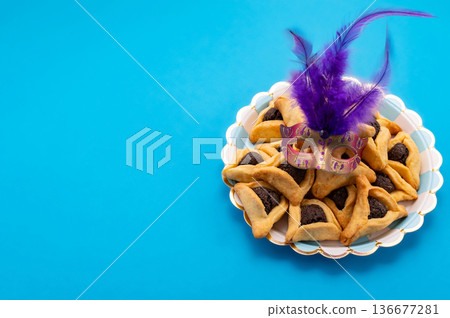 Composition with carnival mask, Hamantaschen cookies and rattle for Purim holiday on color background Composition with carnival mask, Hamantaschen cookies and rattle for Purim holiday on color background 136677281