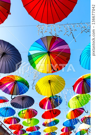 Street with colorful umbrellas hanging above. The sky of colorful umbrellas. Street with colorful umbrellas hanging above. The sky of colorful umbrellas. 136677842
