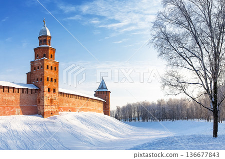 The Kokuy Tower of the Novgorod Kremlin on a cold winter day in Veliky Novgorod, Russia. The Kremlin wall in Veliky Novgorod during a frosty winter sunset. The Kokuy Tower of the Novgorod Kremlin on a cold winter day in Veliky Novgorod, Russia. The Kremlin wall in Veliky Novgorod during a frosty winter sunset. 136677843