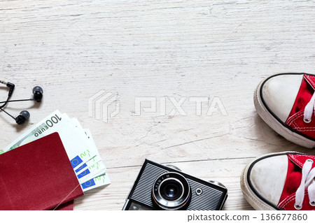 Travel accessories with red sneakers, retro camera and other items on white wooden table with copy space. Travel concept. Travel accessories with red sneakers, retro camera and other items on white wooden table with copy space. Travel concept. 136677860