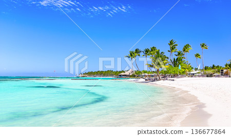 Panorama of beautiful white sand beach and turquoise water of Caribbean sea in Cap Cana, Dominican Republic. Summer beach holiday background Panorama of beautiful white sand beach and turquoise water of Caribbean sea in Cap Cana, Dominican Republic. Summer beach holiday background 136677864