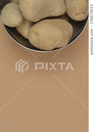 Raw potatoes in a metal bowl with copy space 136678013